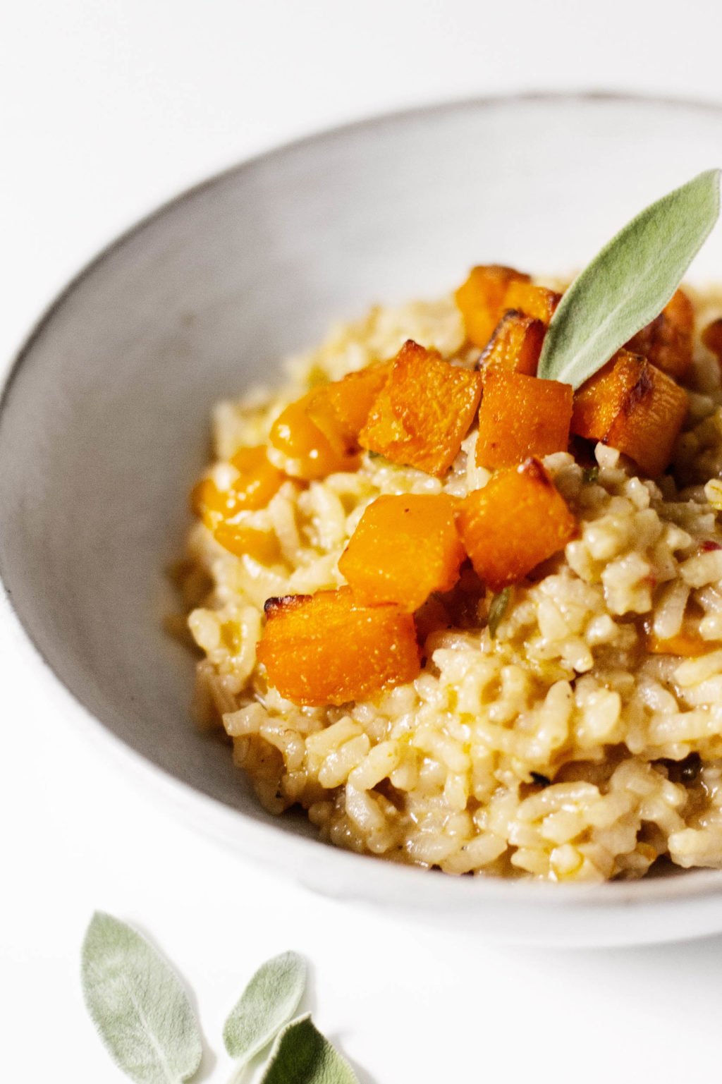 A close up photograph of a creamy vegan risotto, made with tender roasted butternut squash.