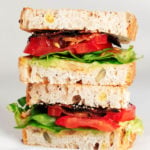 A crosswise section of a stacked, vegan BLT sandwich.