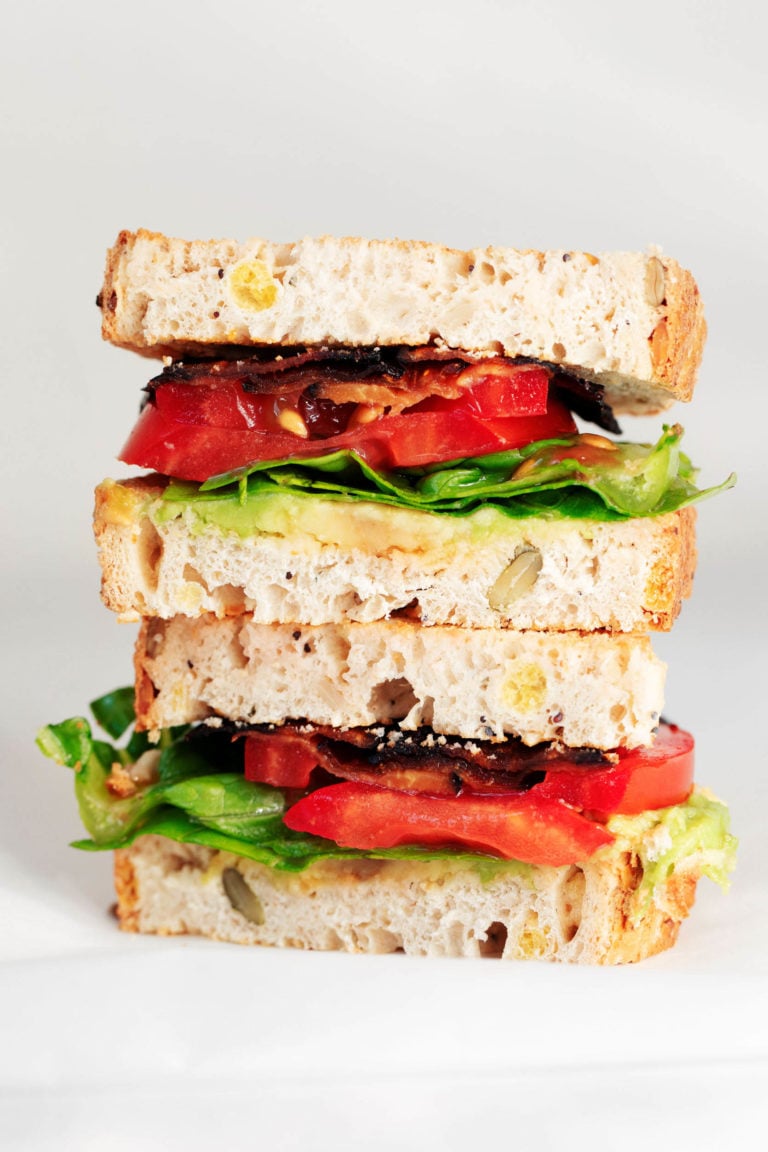 A crosswise section of a stacked, vegan BLT sandwich.
