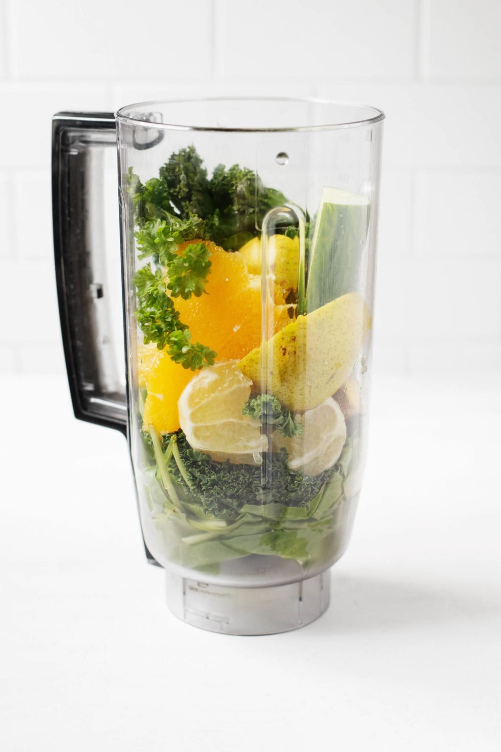 A clear blender is filled with healthful, plant-based ingredients.