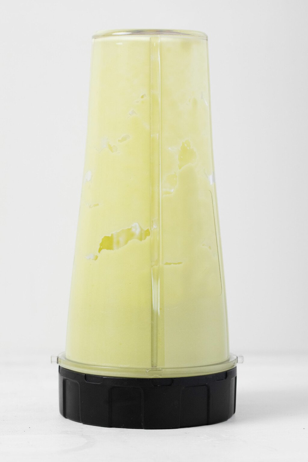 An image of a pale green, avocado vanilla pudding in a mini-blender.