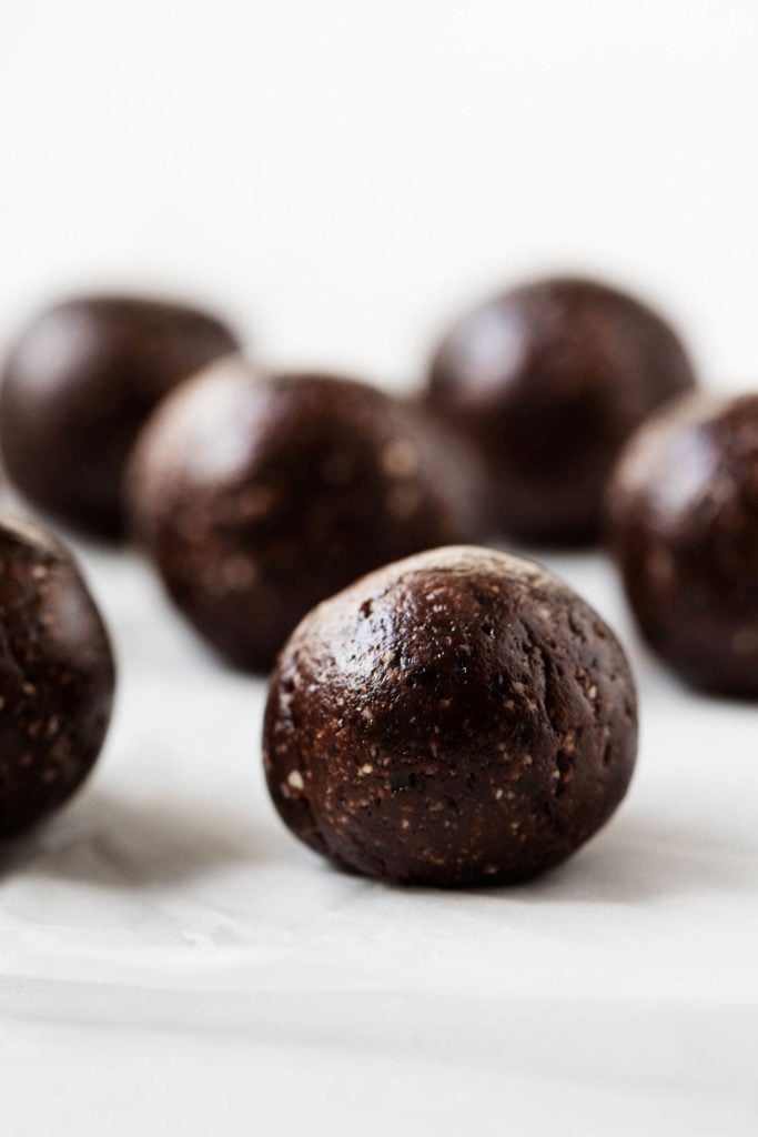 A side angle image of freshly made raw vegan brownie bites.