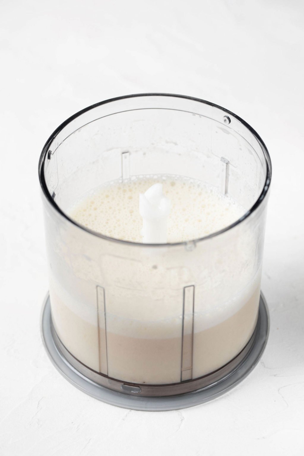 A food processor is filled with non-dairy milk.