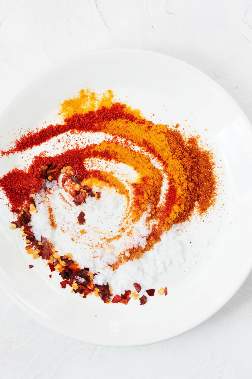 A pinch bowl has been filled with a swirly mixture of spices and salt.