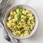 An overhead shot of vegan, gluten free mac n' cheese with green peas.