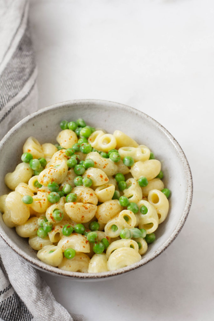 A bowl of vegan, gluten free mac n' cheese, made with green peas.