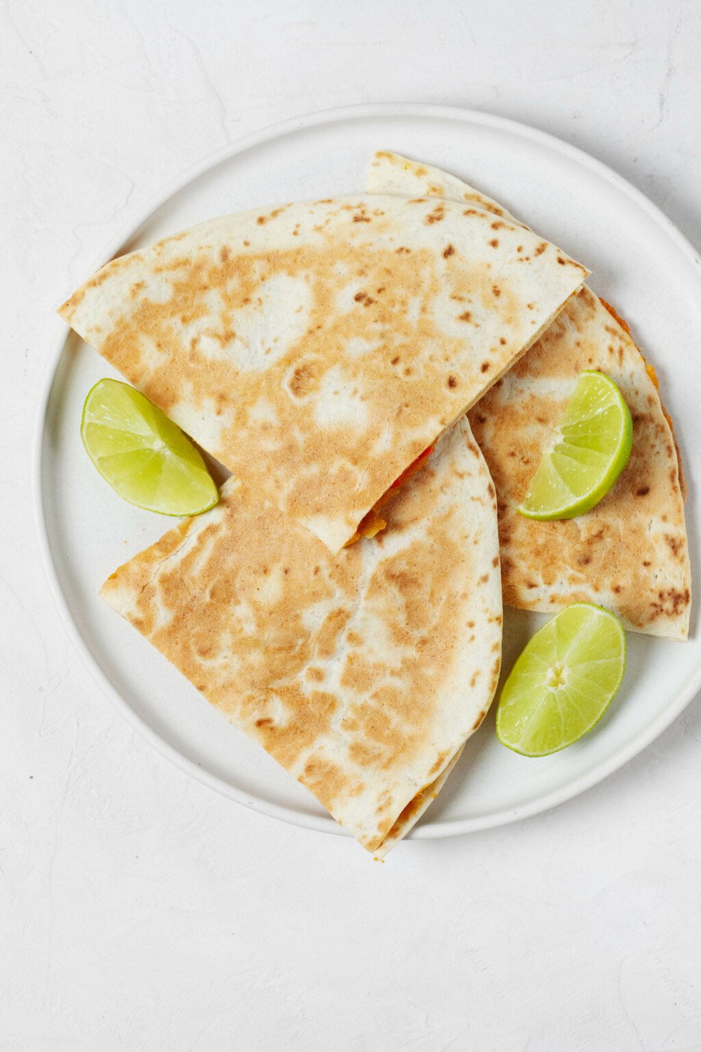 An overhead image of two toasted tortillas, which together create a "sandwich" for a creamy sweet potato filling.