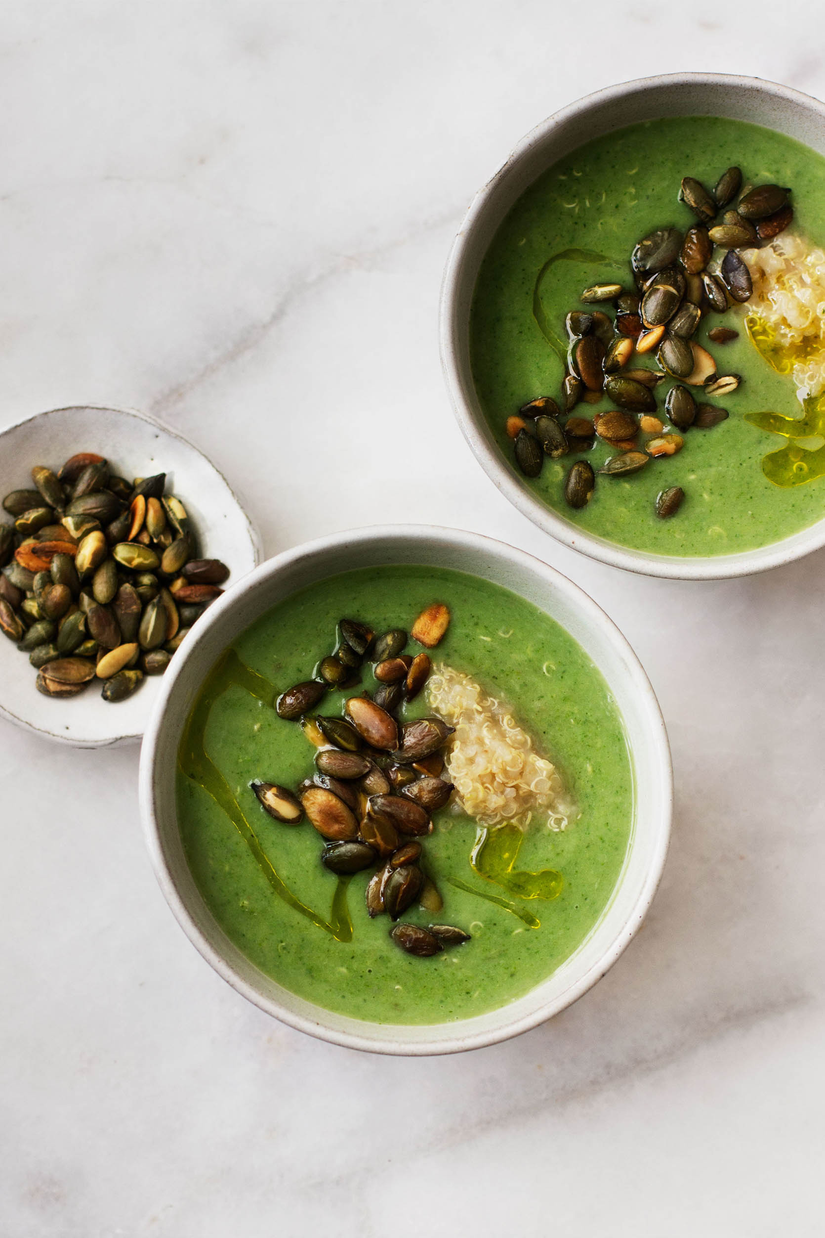 An overhead shot of bright green, vegan broccoli and quinoa soup.