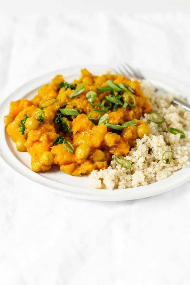 Golden butternut chickpea curry is a fast and flavorful meal—especially when it's served with freshly cooked couscous and chopped green onions.