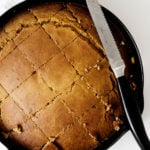 Vegan pumpkin cornbread has been cut into warm squares just after baking.