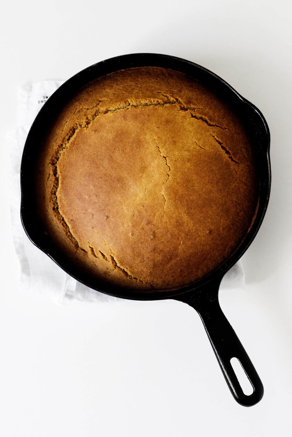 A skillet holding freshly baked, vegan pumpkin cornbread.