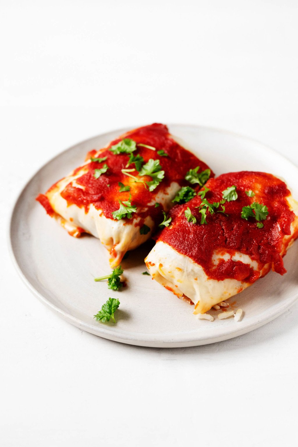 A vegetable dish with tomato sauce has been arranged on a small, round dinner plate.