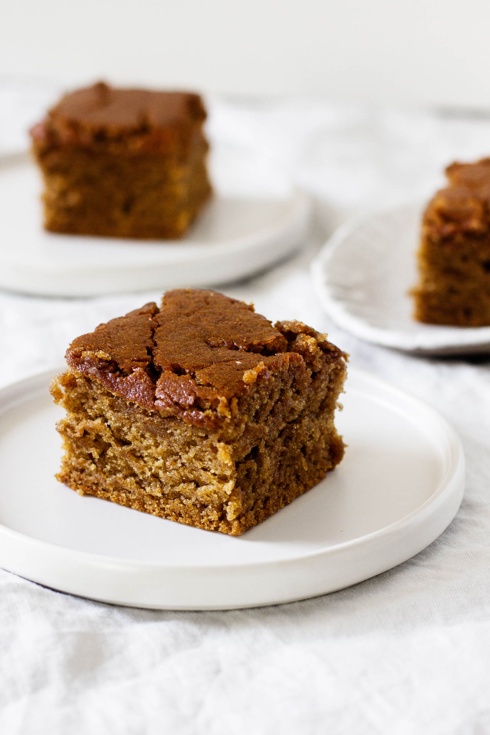 Dessert plates with square slices of vegan, gluten-free gingerbread cake.