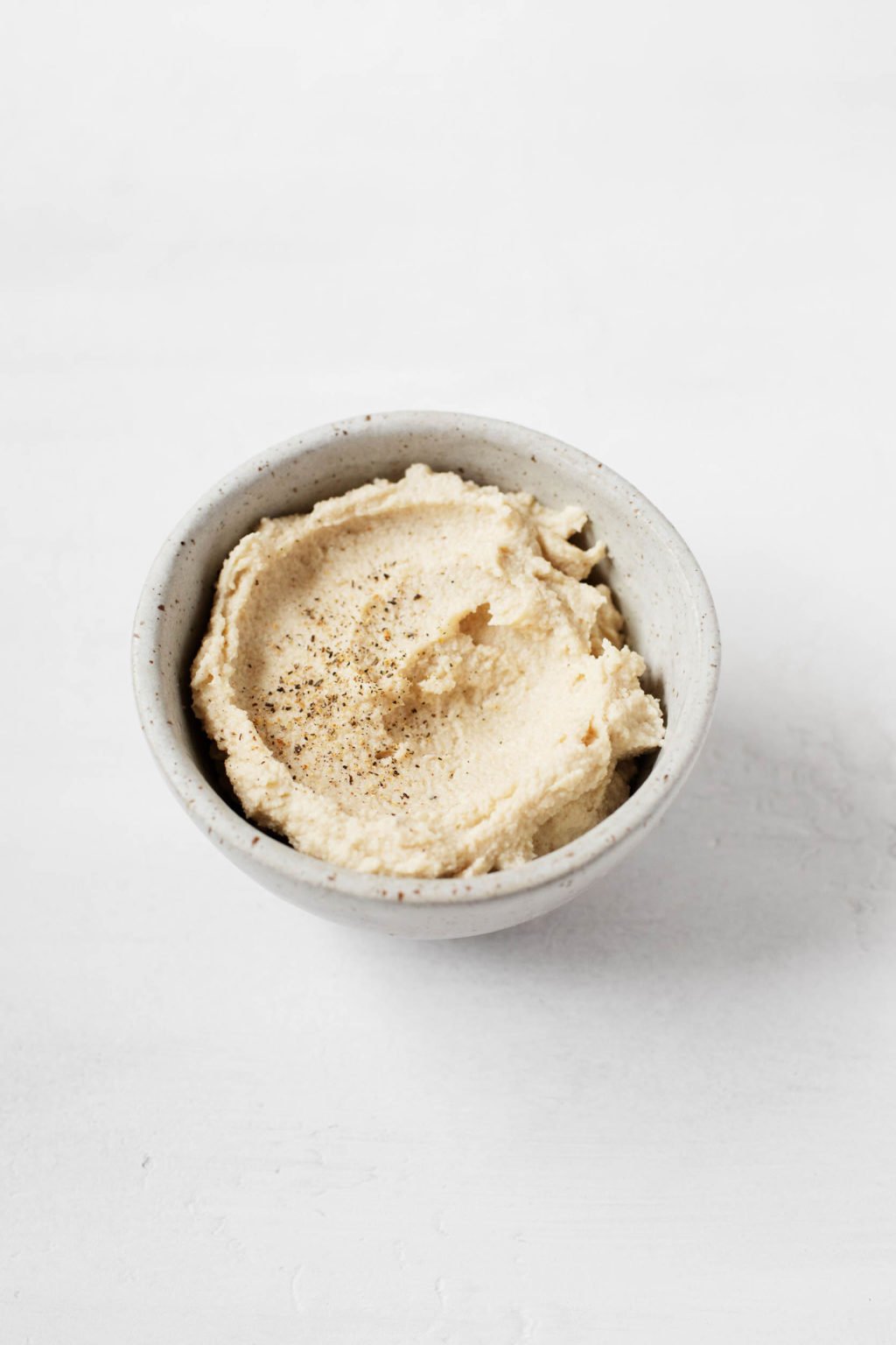 A small pinch bowl is filled with dairy-free, vegan cashew cheese.