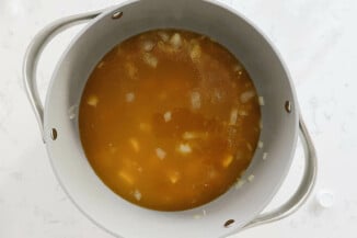 A large white pot holds hot broth and potatoes.
