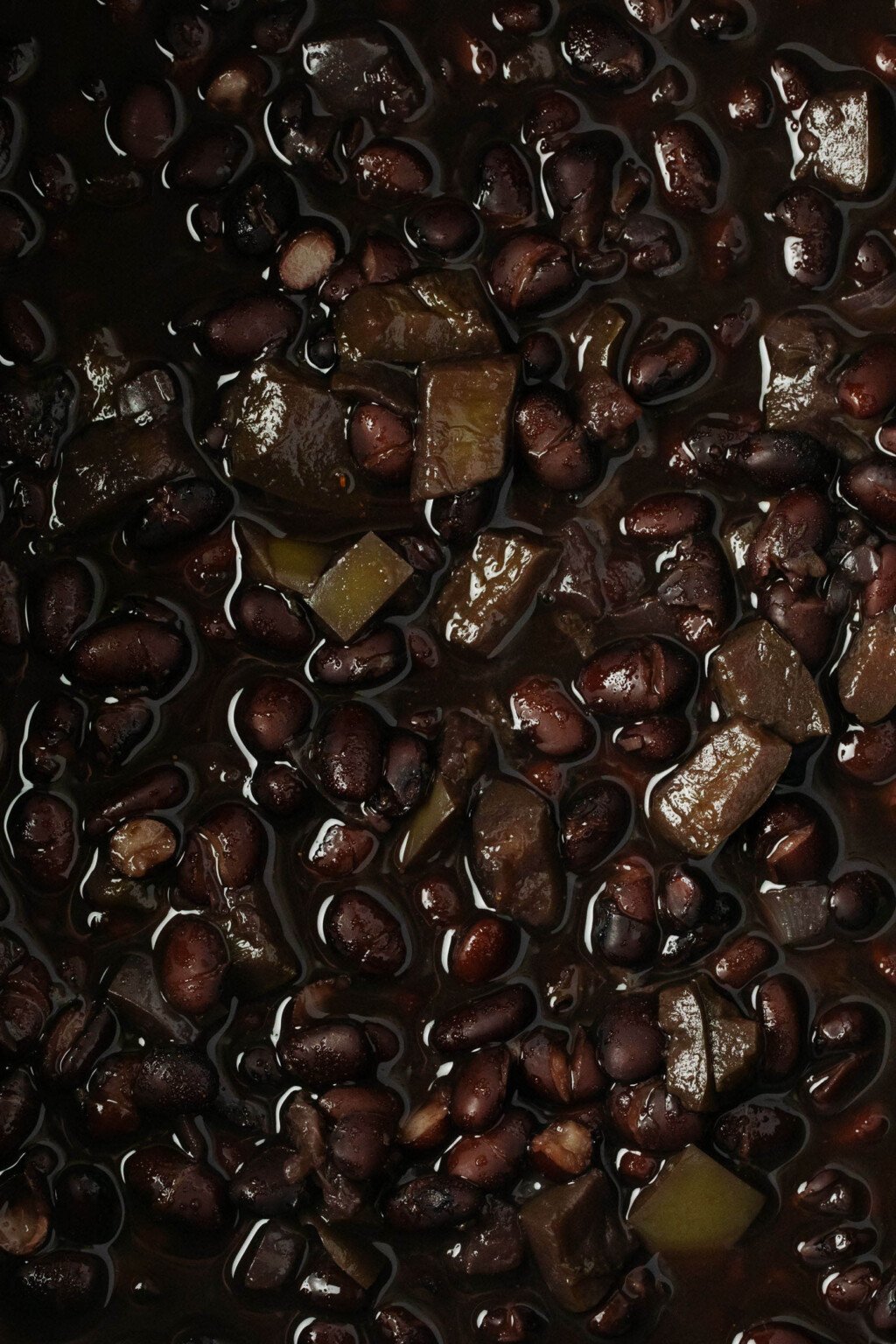 A close up image of cooked black beans and onion.