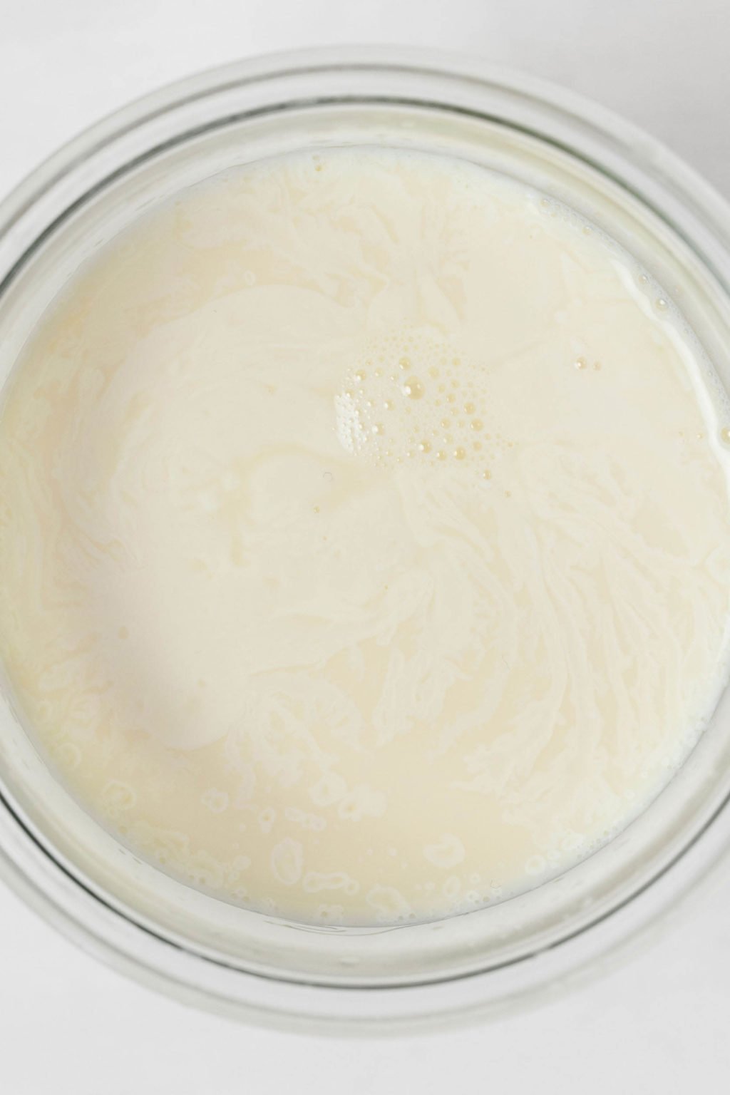 Una imagen de arriba de la leche en un recipiente de vidrio.