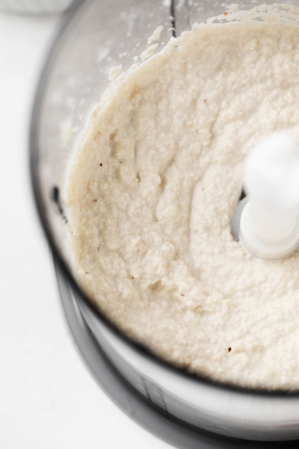 A food processor is blending up a creamy vegan dairy replacement.