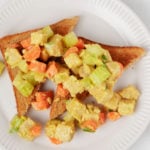 Two triangular slices of toast are topped with an easy tempeh lunch salad.