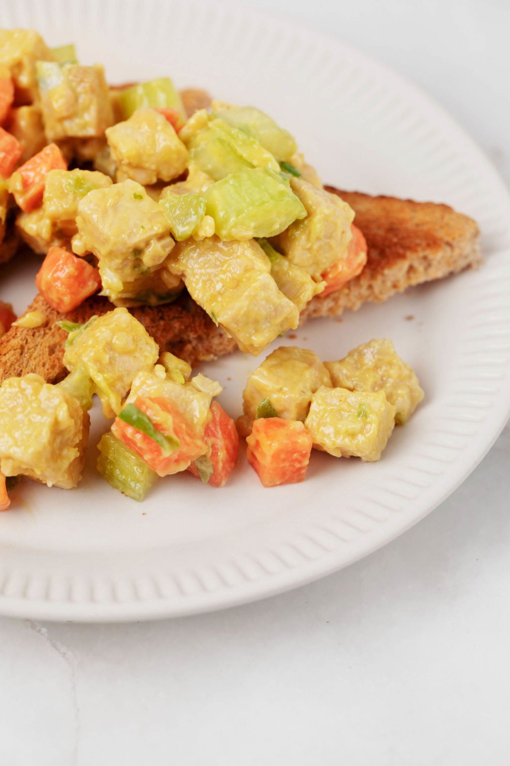 A closeup photo of a vegan protein and vegetables, which is served over toast.