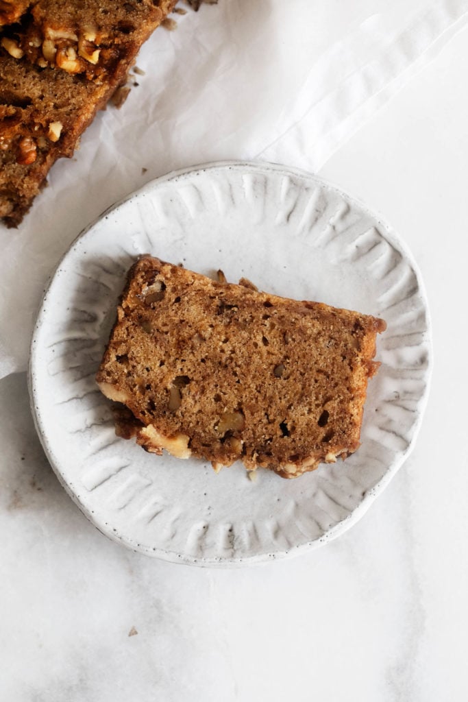 A freshly cut piece of banana bread on a small serving plate.