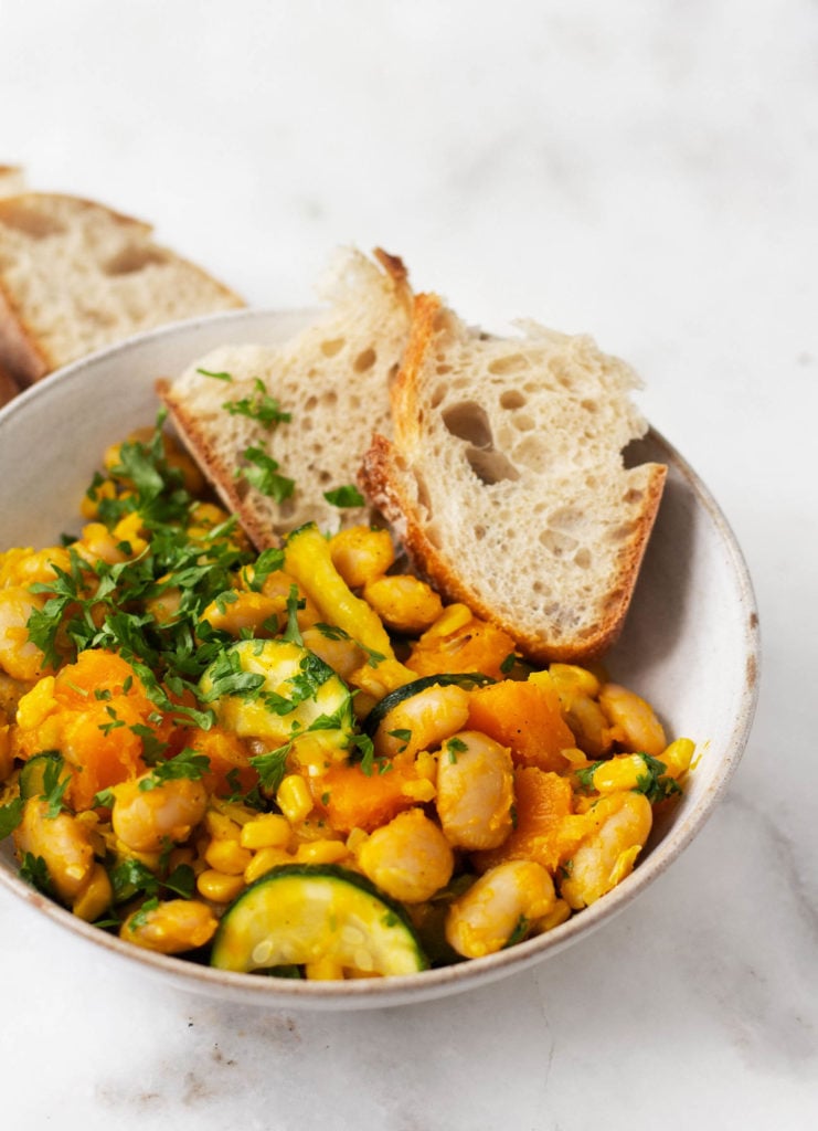 A close up shot of a dish of plant-based lima bean butternut succotash.