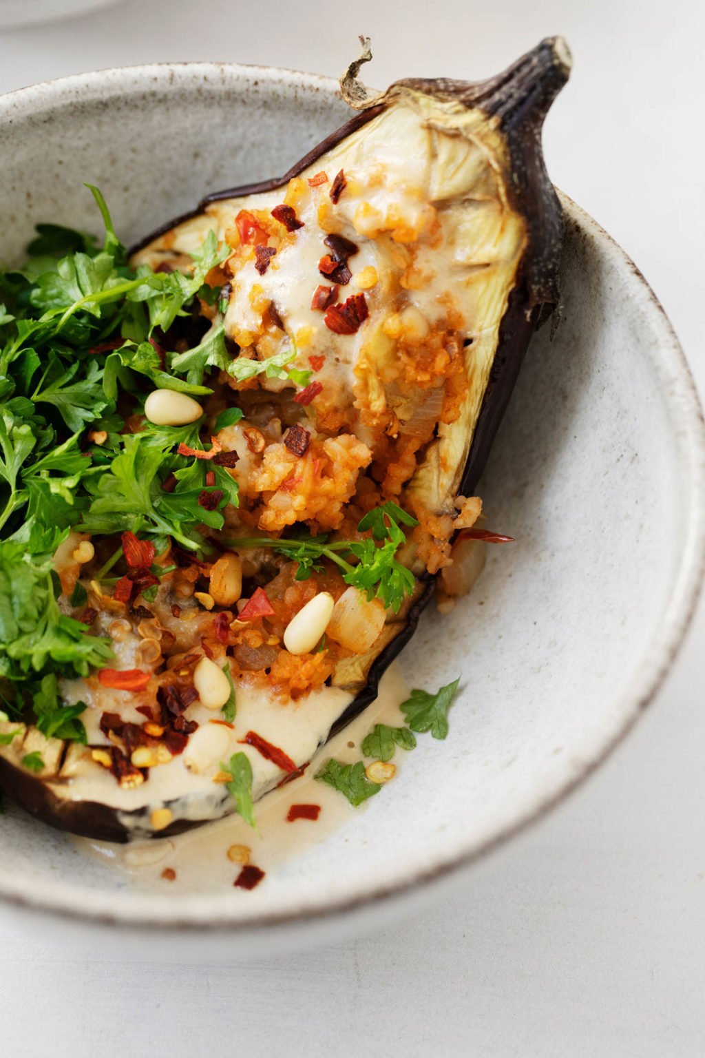 A close up shot of vegan bulgur stuffed eggplants with currants & pine nuts.