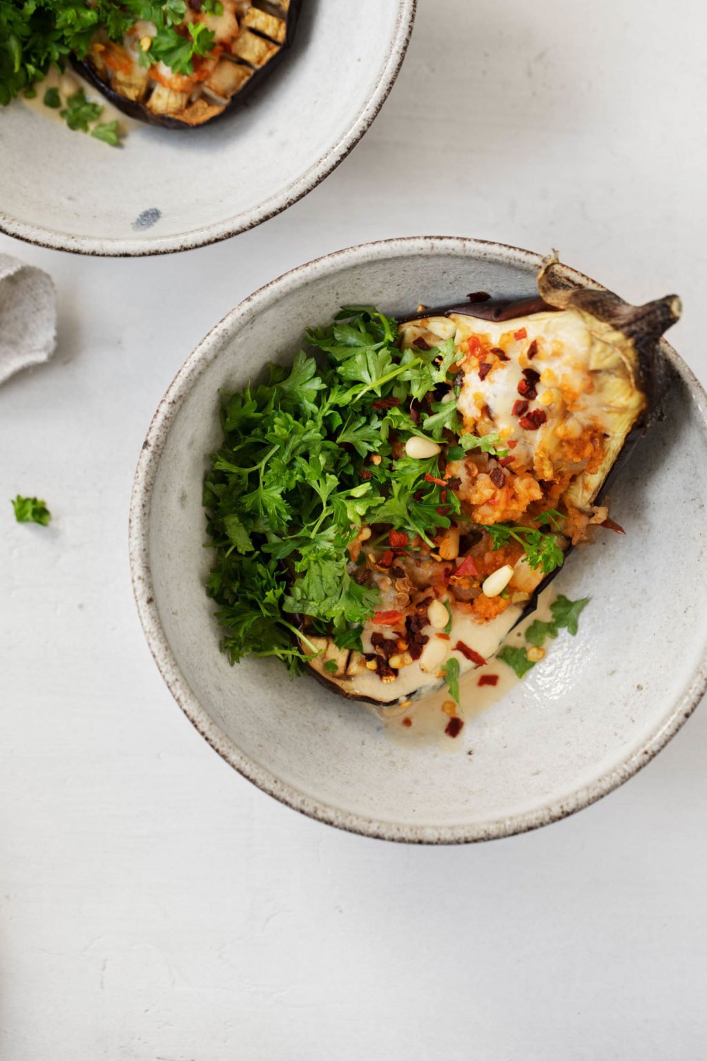 An overhead shot of vegan stuffed eggplants, seasoned with tamarind and garnished with fresh parsley.