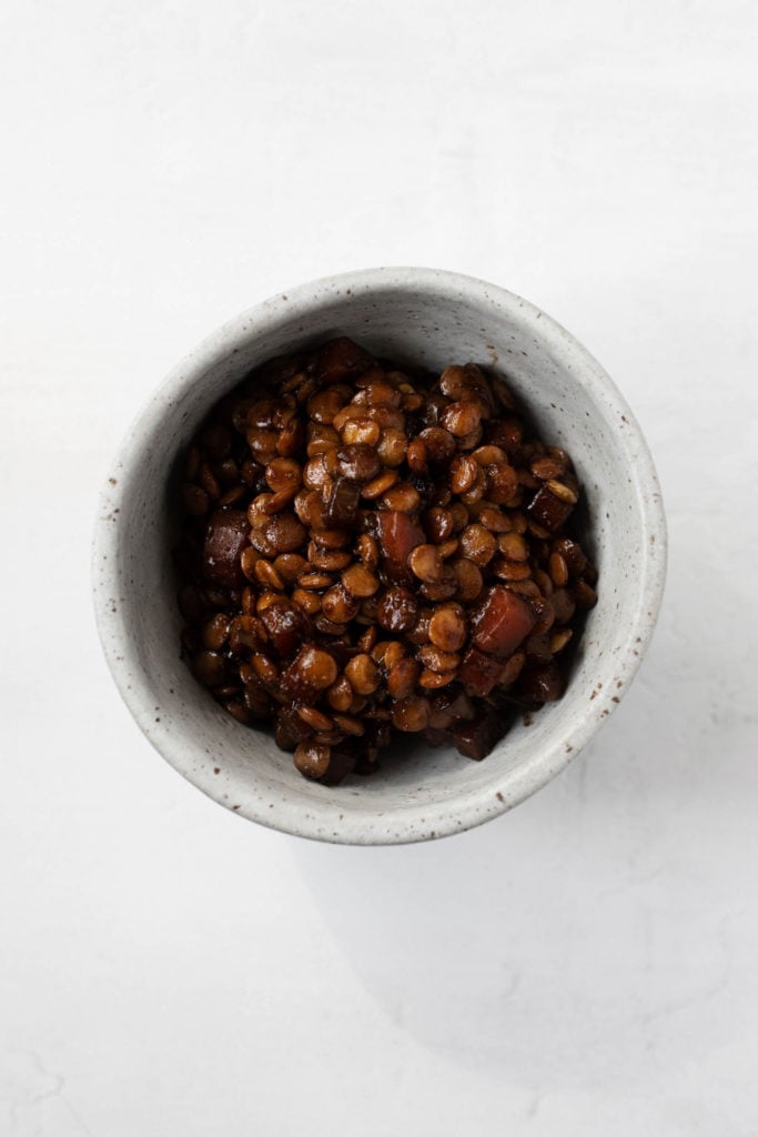 A small bowl of lentils that have been braised in red wine.