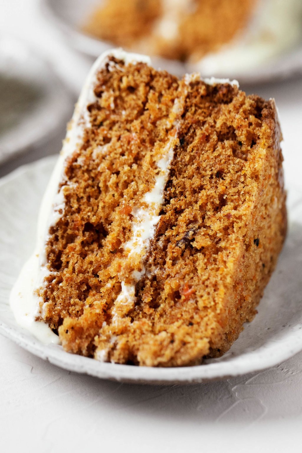 A big slice of carrot pumpkin cake, studded with raisins and walnuts.