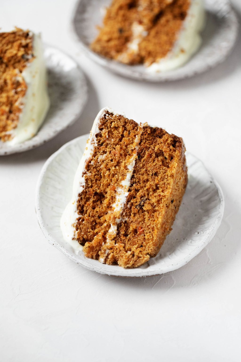 A few dessert plates with slices of autumnal frosted cake.