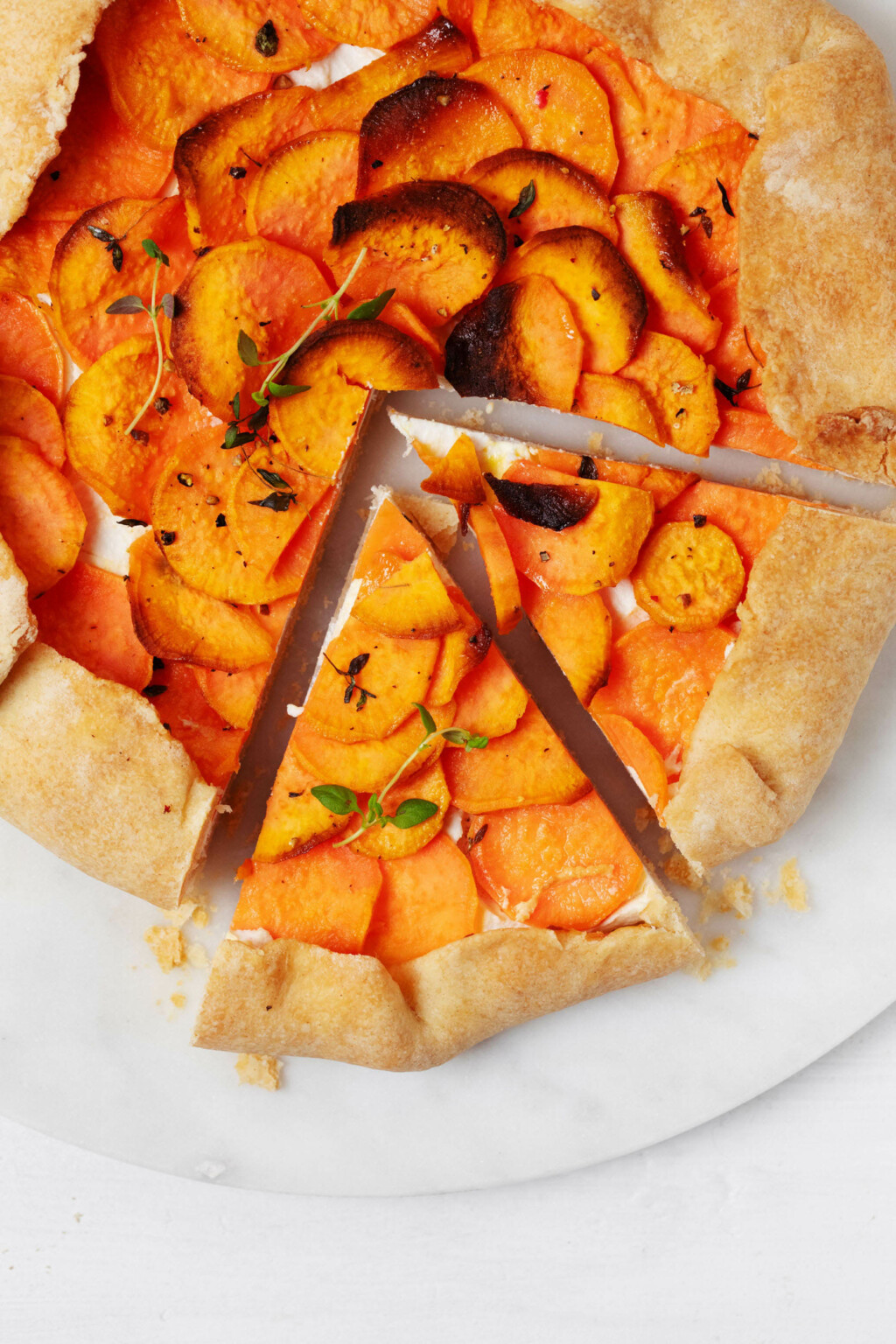 A close up, overhead image of a baked vegan sweet potato galette, which has been cut into triangle-shaped wedges.