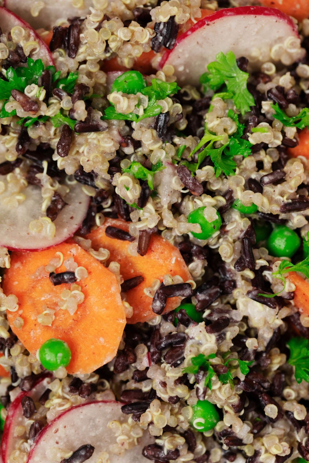 A close-up image of a medley of grains, herbs, and vegetables.