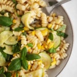 A vibrant dish of pasta with sweet summer corn, zucchini, and herbs