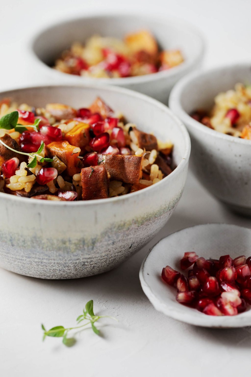 Several bowls contain the ingredients for a vegan rice and sweet potato holiday side dish.
