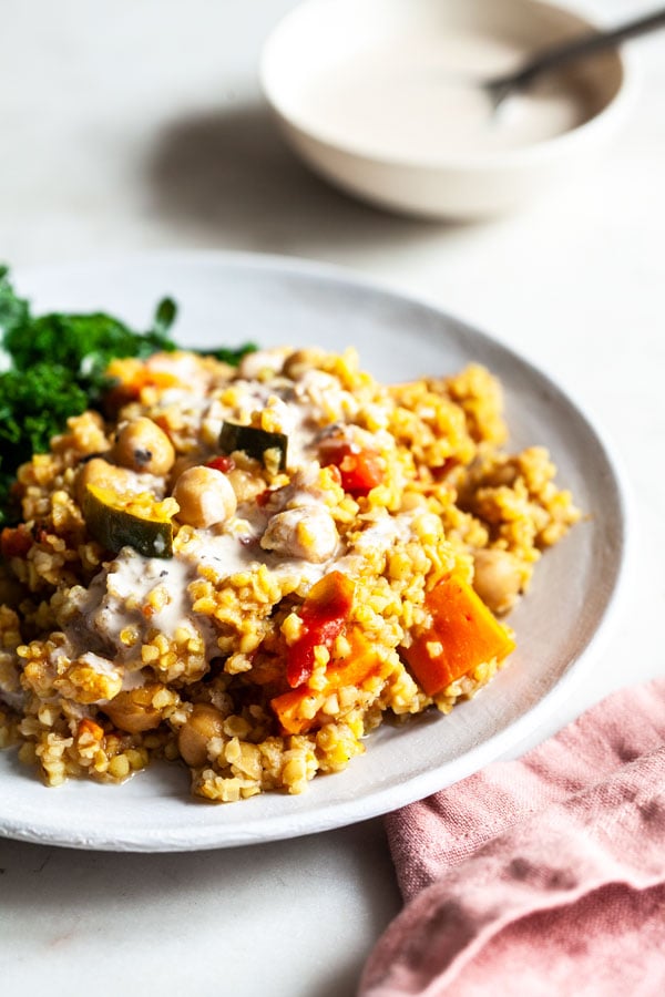 Simple Baked Bulgur & Chickpeas Dish Recipe - This dish of simple baked bulgur & chickpeas is rich in fiber, protein, an array of phytonutrients, and it’s easy to prepare. Served with a bright, creamy tahini dressing! #chickpeas #dish #bakedbulgur #maindish #easydinnerrecipe