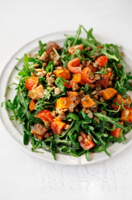 A round white plate has been covered in a colorful, creamy lentil tahini sweet potato salad.