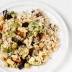 An overhead image of a plate covered in zucchini chickpea rice, which is garnished with fresh dill.