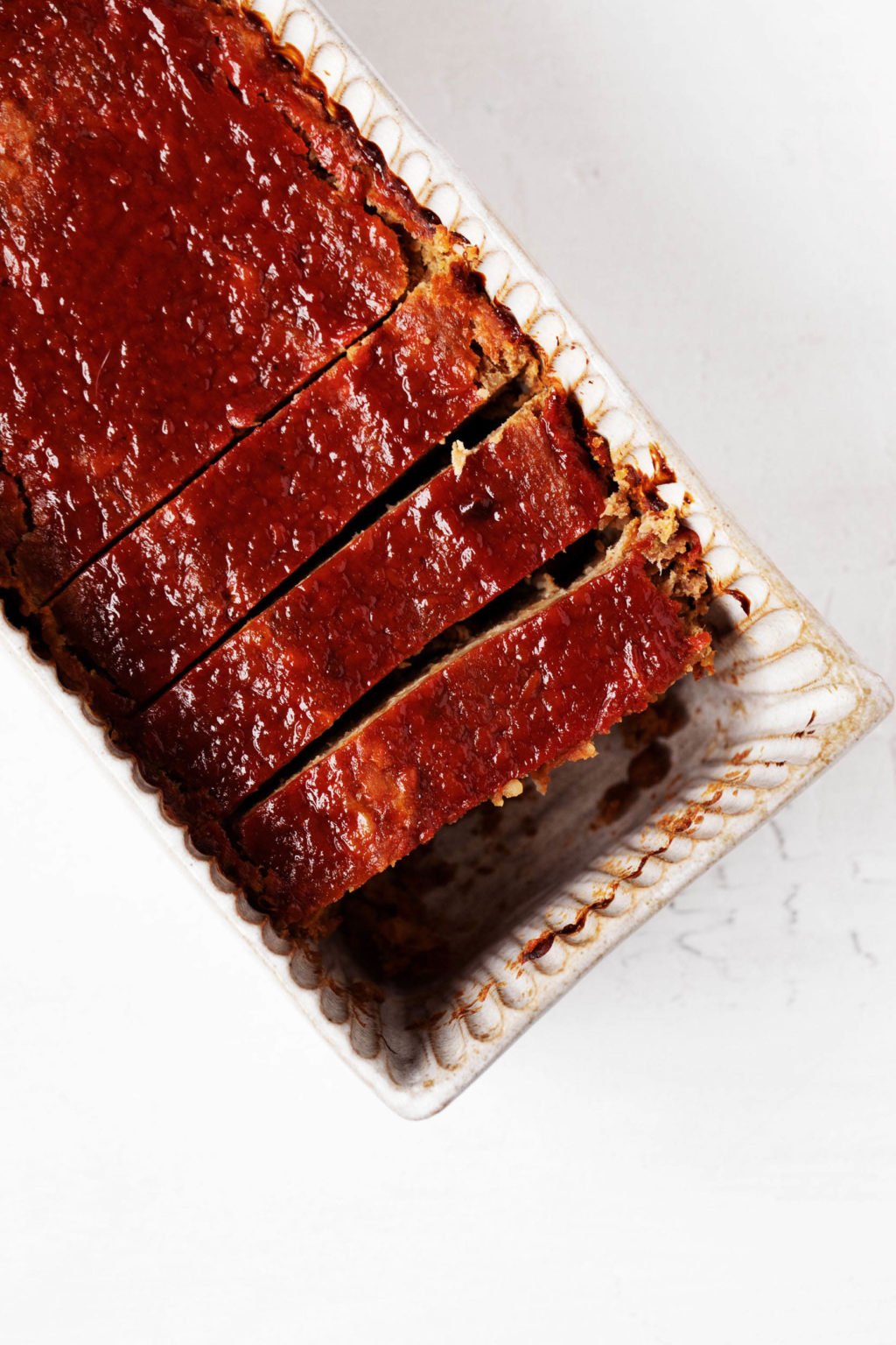An overhead image of freshly baked, vegan meatloaf, topped with ketchup glaze.