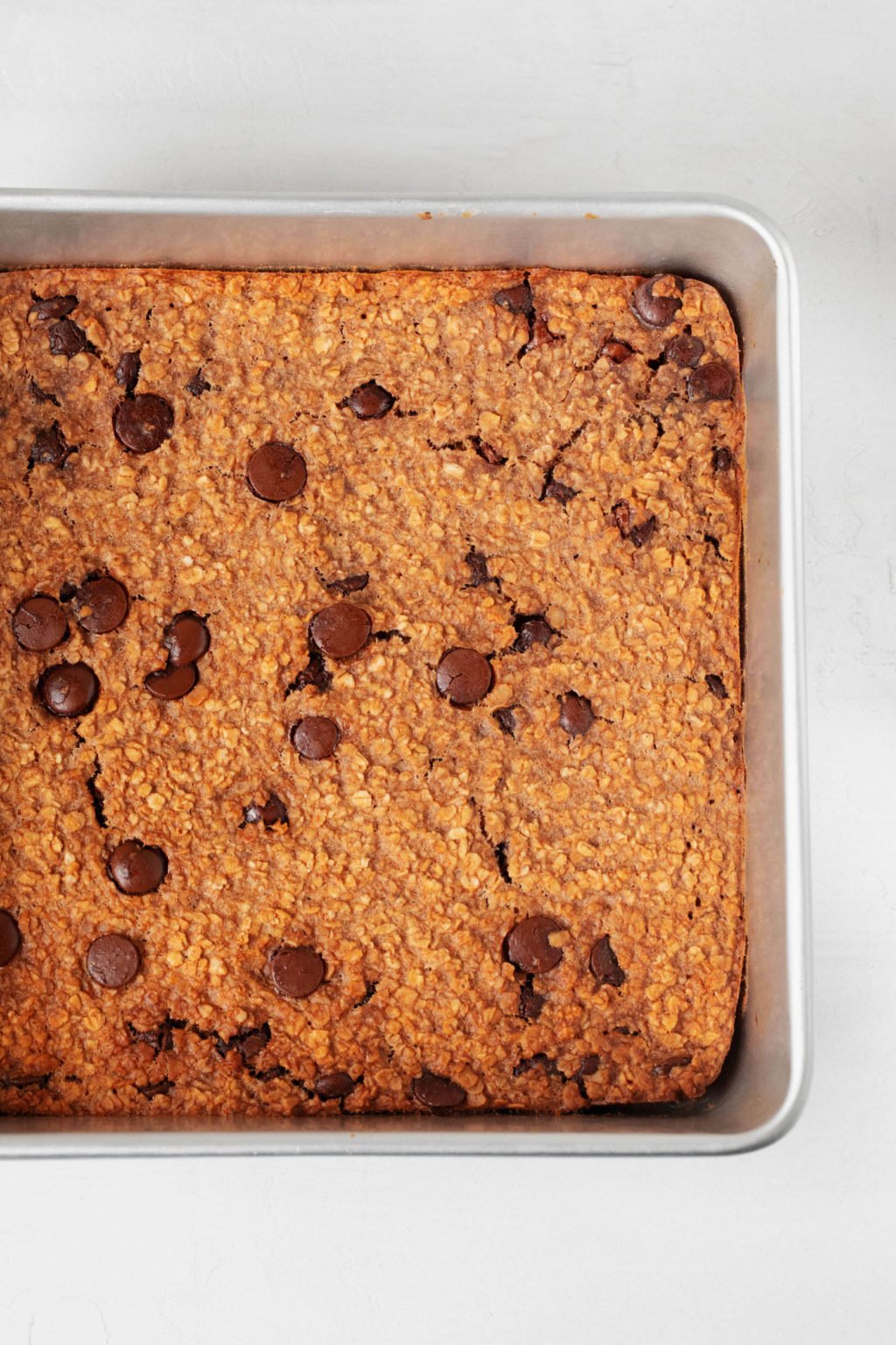 A square, aluminum baking dish is filled with a baked mixture of whole grains.