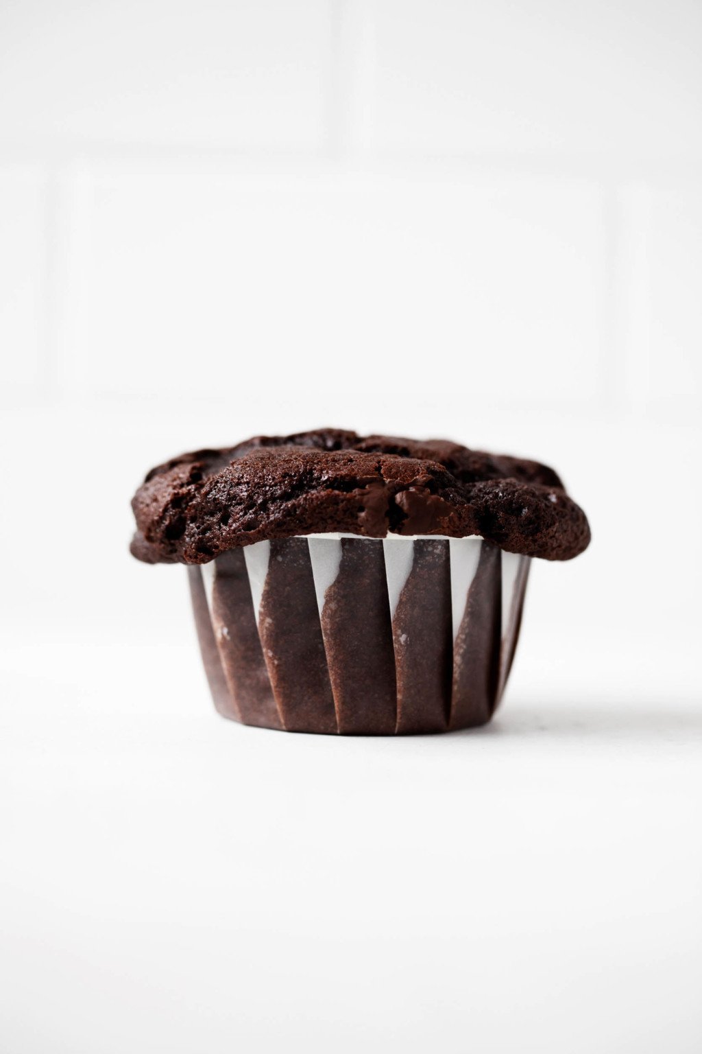 A single vegan chocolate muffin has been baked in a cupcake liner.