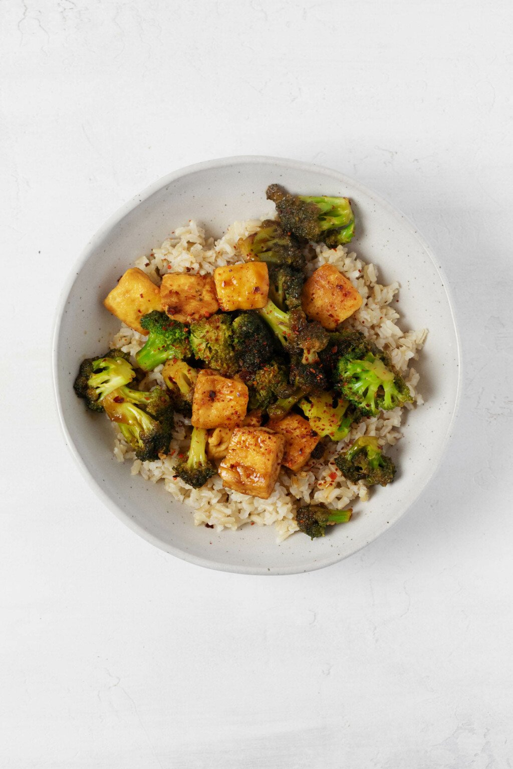 An overhead image of a broccoli tofu stir fry, which has been served over a bed of brown rice.