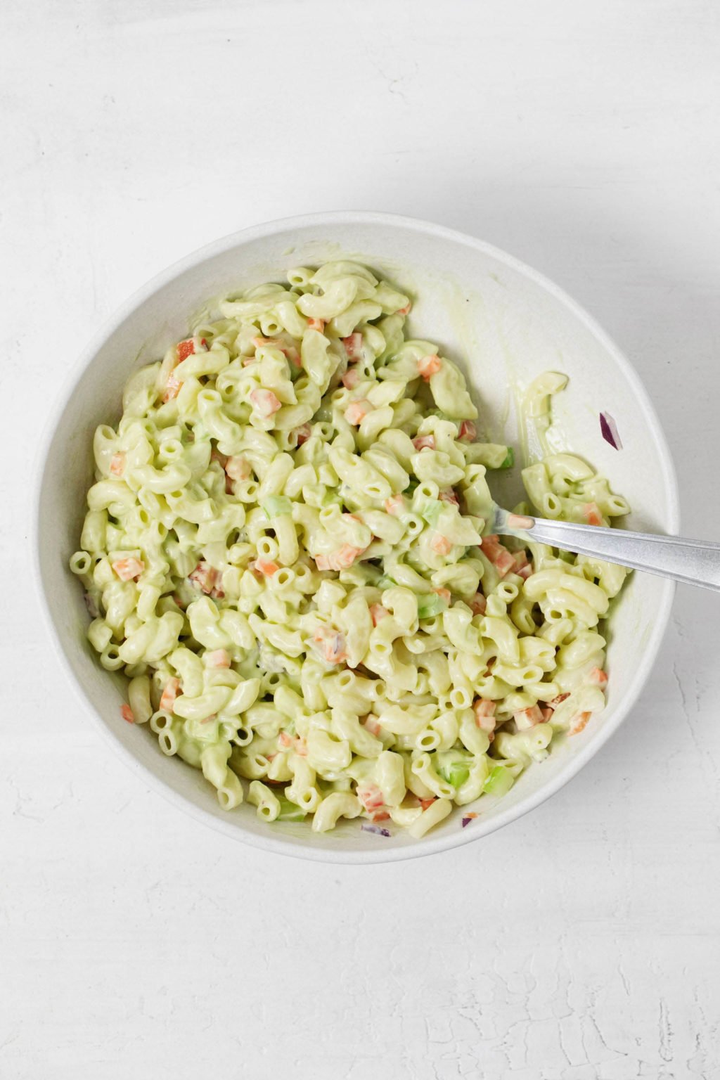 An overhead image of a creamy vegan macaroni salad, made with avocado sauce.