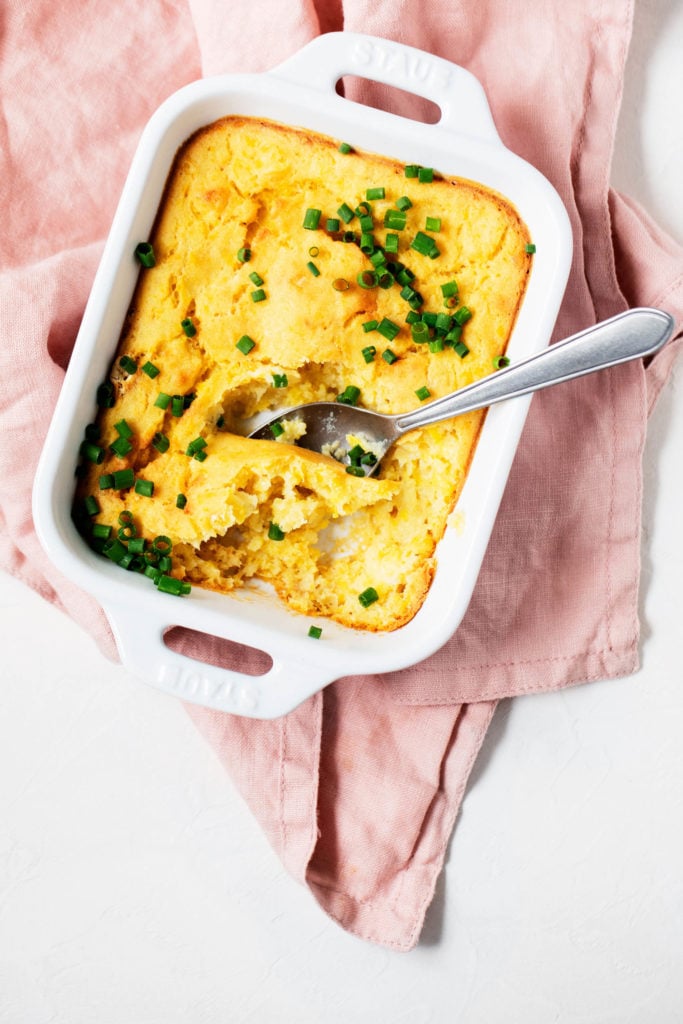 An overhead short of vegan corn pudding, freshly baked in a casserole dish.