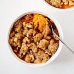 A small ramekin holds a single serving of vegan sweet potato casserole.