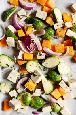 A sheet pan covered with autumn vegetables and tofu, ready for baking.