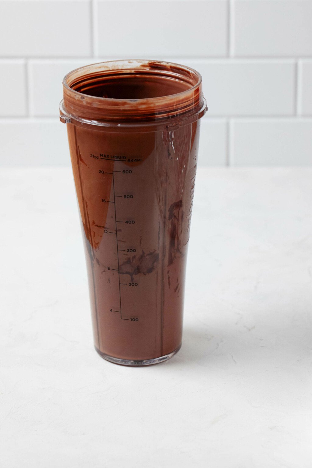 The container of a portable blender is filled with a rich, chocolate mixture.