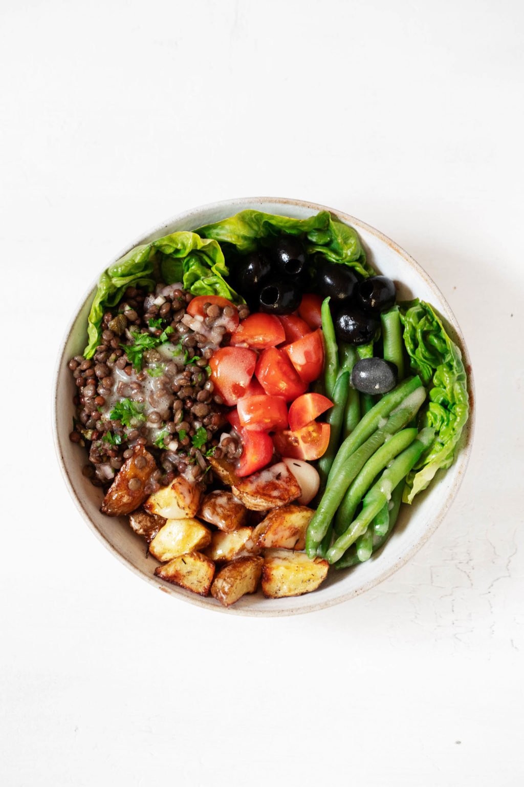 An overhead photograph of a composed salad, which has been made with an array of colorful plant-based ingredients.