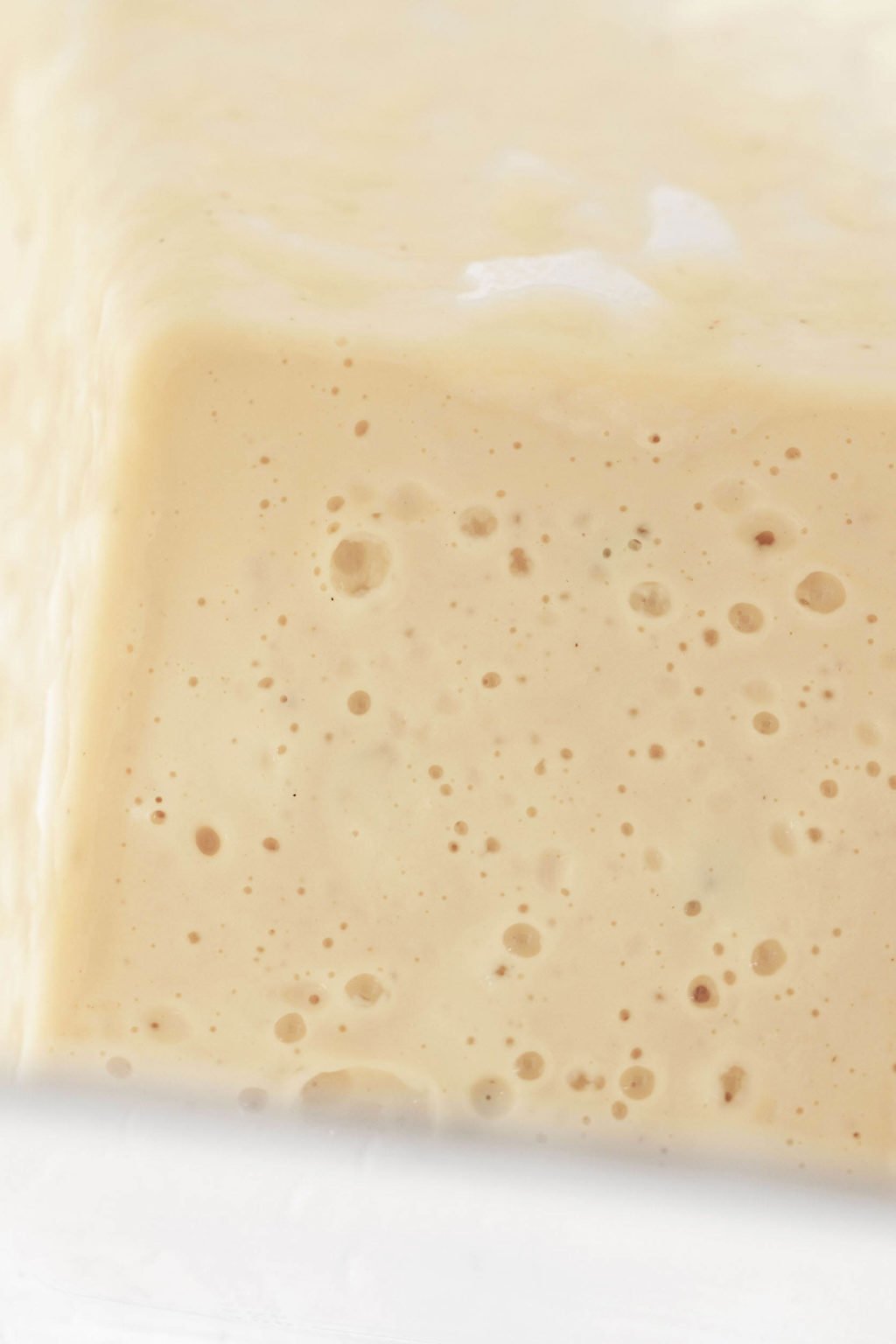 An overhead image of a creamy, white sauce, which has just been prepared in a blender.