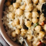 A dish of chickpeas à la King has been served over a bed of brown rice.